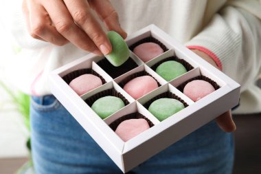 Kutunun üstünde nefis mochi tutan kadın, yakın plan.