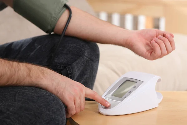 Mann Kontrolliert Blutdruck Holztisch Drinnen Nahaufnahme — Stockfoto