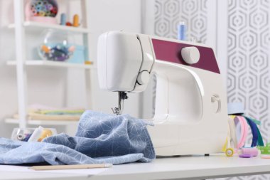 Modern dikiş makinesi, kumaş ve aksesuarlar masa içinde.