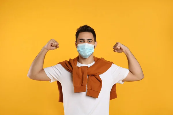 Man Protective Mask Showing Muscles Yellow Background Strong Immunity Concept — Stock Photo, Image