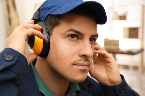 在室内戴安全耳机的工人 听觉保护装置 — 图库照片