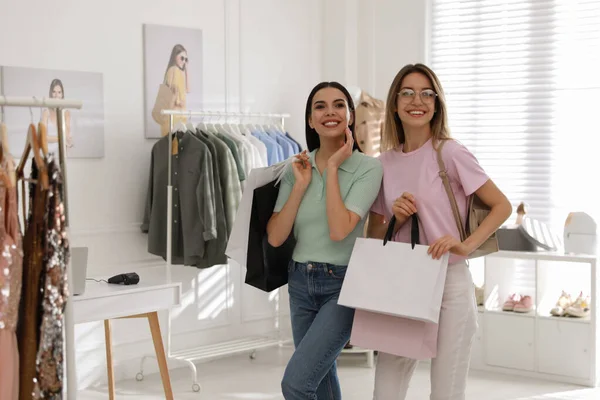 Mujeres Jóvenes Con Bolsas Compras Elegir Ropa Boutique Moderna Espacio — Foto de Stock