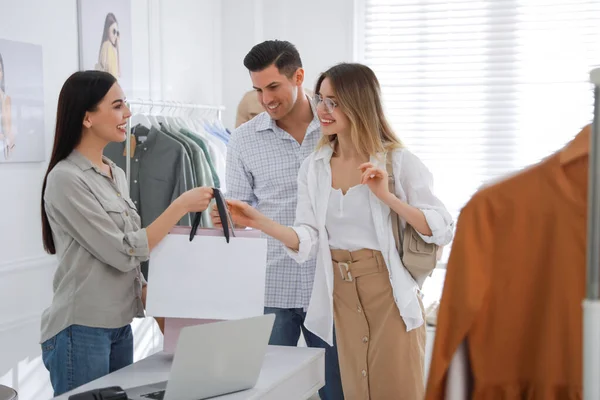 Mağaza Görevlisi Modern Butikte Eşlere Giysi Dolu Çantalar Veriyor — Stok fotoğraf