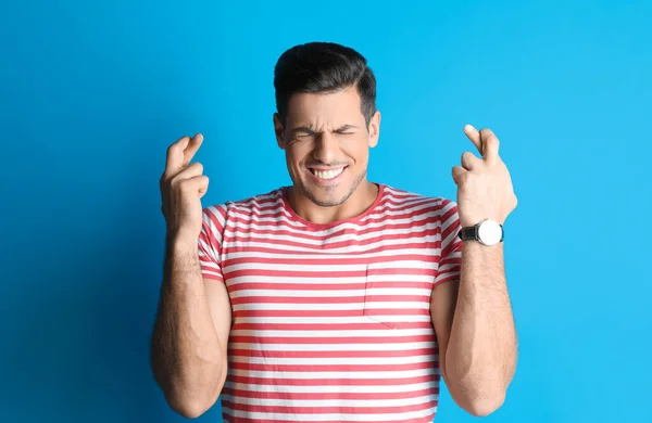 Man Crossed Fingers Light Blue Background Superstition Concept — Stock Photo, Image