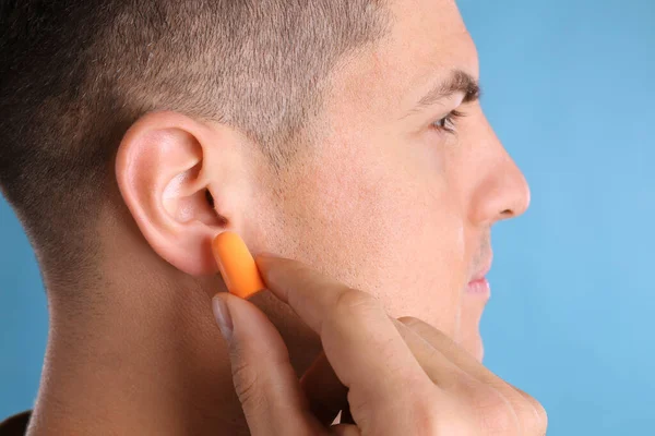 Hombre Insertando Tapón Espuma Fondo Azul Claro Primer Plano — Foto de Stock