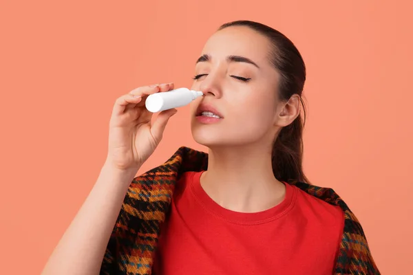 Mujer Usando Spray Nasal Sobre Fondo Melocotón — Foto de Stock