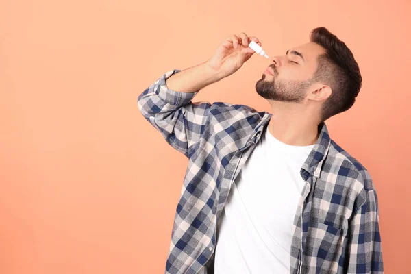Hombre Usando Spray Nasal Sobre Fondo Melocotón Espacio Para Texto — Foto de Stock