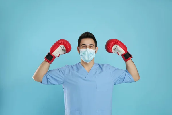 Läkare Med Skyddsmask Och Boxningshandskar Ljusblå Bakgrund Starkt Immunitetsbegrepp — Stockfoto