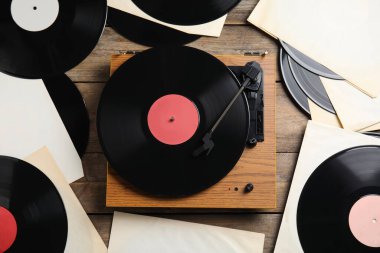 Ahşap arka planda modern oyuncu ve vinil plaklar, düz konum