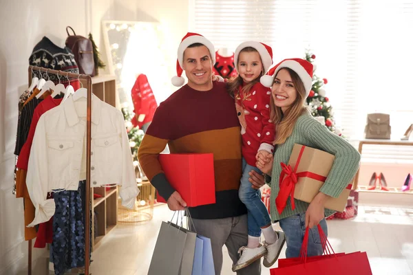 サンタの帽子を持つ幸せな家族は店でクリスマスショッピングを行う — ストック写真