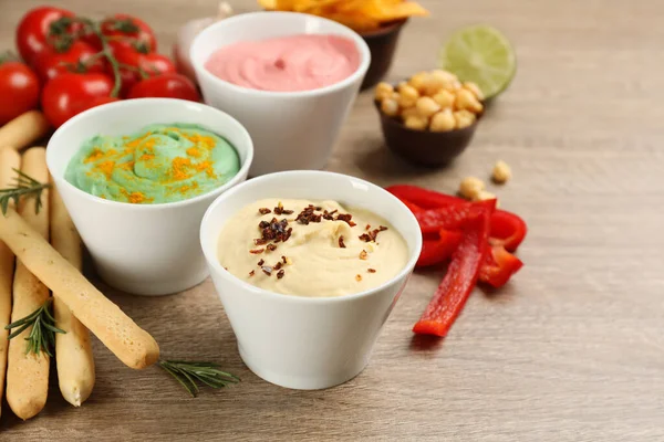 Verschillende Soorten Smakelijke Hummus Geserveerd Met Broodstokjes Houten Tafel — Stockfoto