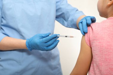 Doktor hastahanede küçük bir kıza iğne yapıyor. Dokunulmazlık kavramı