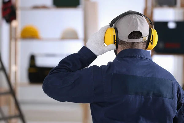 Pracownik Noszący Słuchawki Bezpieczeństwa Pomieszczeniu Widok Tyłu Urządzenie Zabezpieczające Słuch — Zdjęcie stockowe