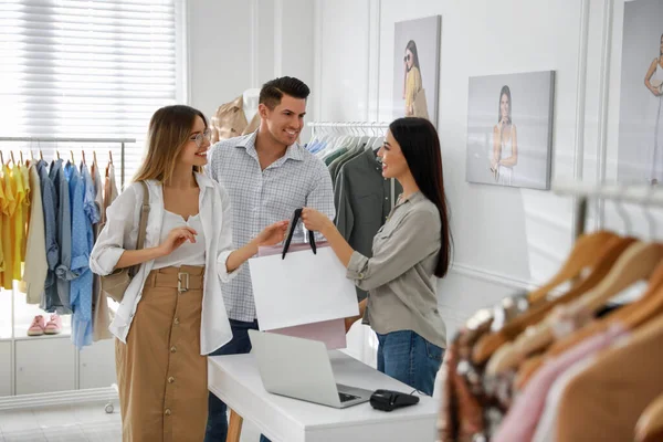 Mağaza Görevlisi Modern Butikte Eşlere Giysi Dolu Çantalar Veriyor — Stok fotoğraf