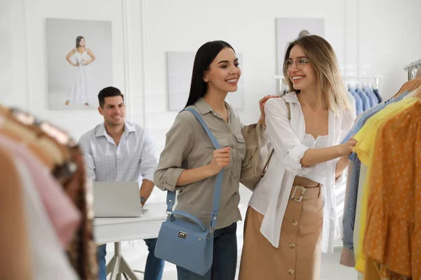 Mujeres Jóvenes Eligiendo Ropa Cerca Rack Boutique Moderna — Foto de Stock