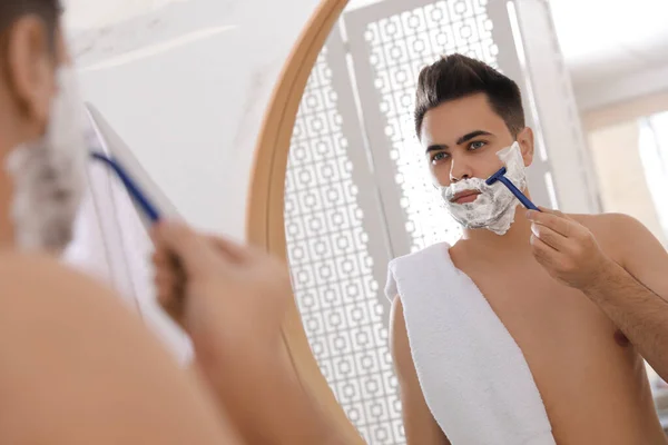 Beau Jeune Homme Rasage Avec Rasoir Près Miroir Dans Salle — Photo