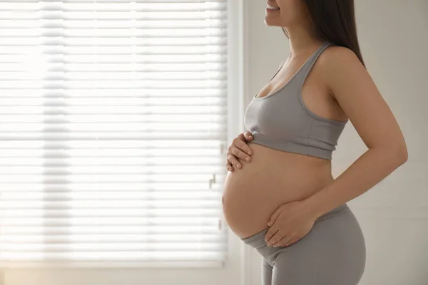 Zwangere Jonge Vrouw Raakt Buik Buurt Van Raam Binnen Close — Stockfoto