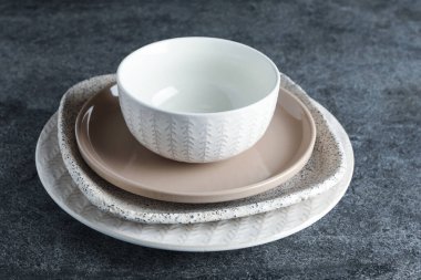 Gri masada bir yığın temiz bulaşık.