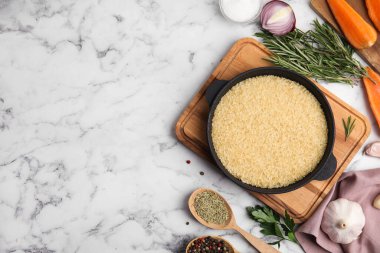 Beyaz mermer masada tavada kuru pirinçli düz kompozisyon. Metin için boşluk