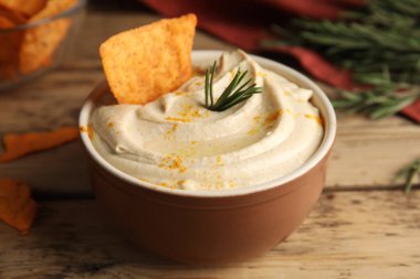 Tahta masadaki biberiyeli ve nachos ile nefis humus, yakın plan.