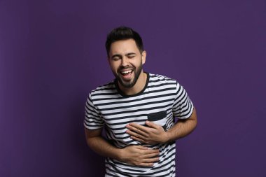 Genç adam mor arka planda gülüyor. Komik şaka.