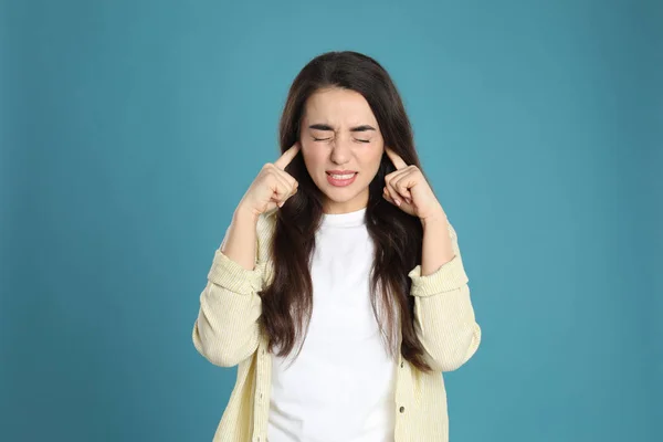 Emocional Jovem Mulher Cobrindo Orelhas Com Dedos Fundo Azul Claro — Fotografia de Stock