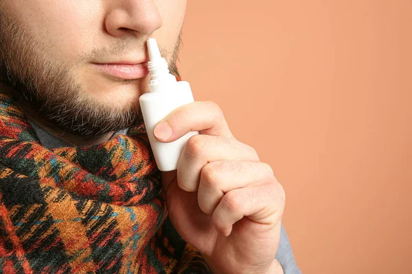 Hombre Enfermo Usando Aerosol Nasal Sobre Fondo Naranja Primer Plano — Foto de Stock