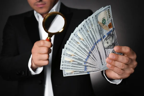 Expert Authenticeren 100 Dollar Bankbiljetten Met Vergrootglas Tegen Donkere Achtergrond — Stockfoto