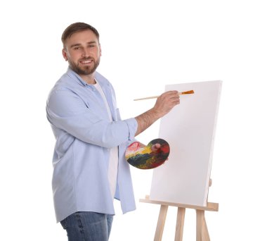 Beyaz arka planda fırçayla resim yapan adam. Genç sanatçı