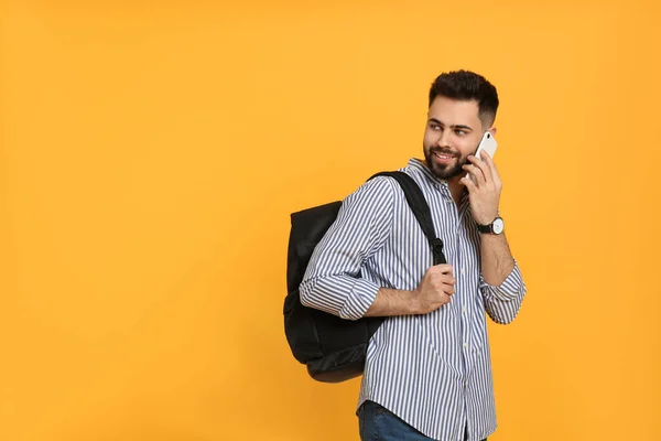 Jovem Com Mochila Elegante Falando Telefone Contra Fundo Amarelo Espaço — Fotografia de Stock