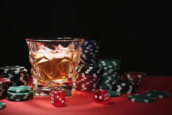 红桌上的赌场薯片 骰子和威士忌 黑色背景 文字空间 — 图库照片