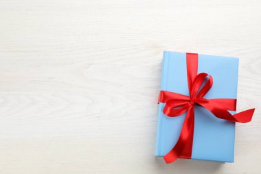 Kitaplar kırmızı kurdeleyle bağlanmış, beyaz tahta masa, üst manzara. Metin için boşluk