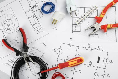 Elektrikçi aletleri ile düz kompozisyon ve masa üzerinde ev planı kağıtları