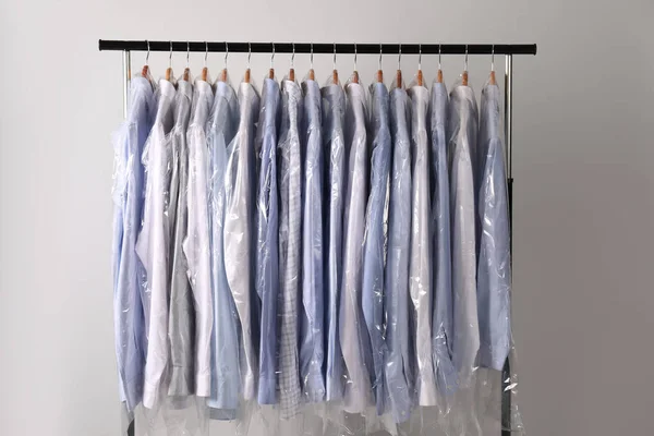 Appendini Con Camicie Sacchetti Plastica Lavaggio Secco Rack Sullo Sfondo — Foto Stock