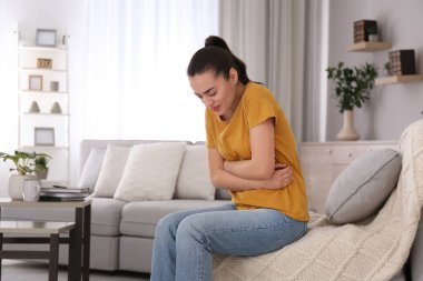 Evde karın ağrısı çeken genç bir kadın, mesaj için yer var. Gıda zehirlenmesi