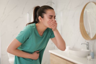 Young woman suffering from nausea in bathroom. Food poisoning clipart