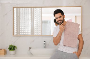 Banyoda traş olduktan sonra yakışıklı genç adam, mesaj atmak için yer.