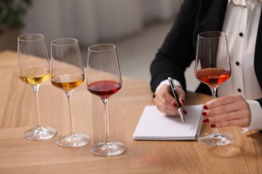 Sommelier içerideki masada farklı türde şarap tadıyor, yakın plan.