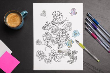 Stres önleyici boyama sayfası, kalemler ve kahve siyah masada, düz yatıyordu.