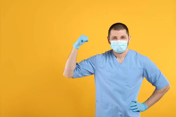 Dokter Met Beschermend Masker Toont Spieren Gele Achtergrond Ruimte Voor — Stockfoto