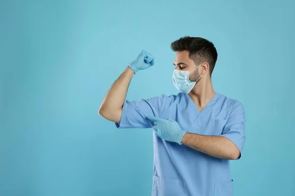 Läkare Med Skyddsmask Och Handskar Som Visar Musklerna Ljusblå Bakgrund — Stockfoto