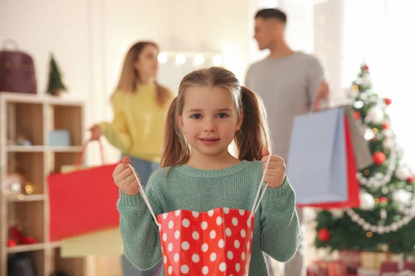 両親のそばに袋を持った少女が店にいる ファミリークリスマスショッピング — ストック写真