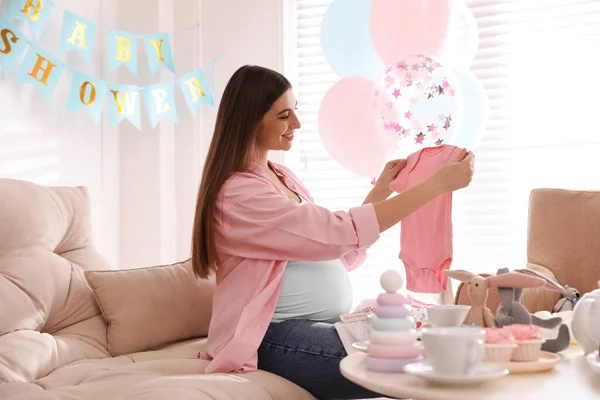 快乐的孕妇在婴儿淋浴派对上装饰的房间里抱着一个 — 图库照片