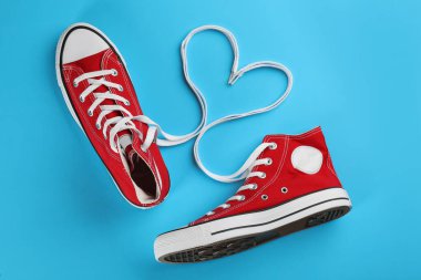 Açık mavi arka planda bir çift modaya uygun spor ayakkabısı.