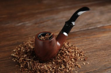 Ahşap masasında tütün bulunan klasik tütün piposu.