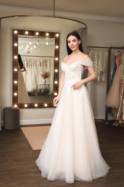 Woman trying on wedding dress in boutique