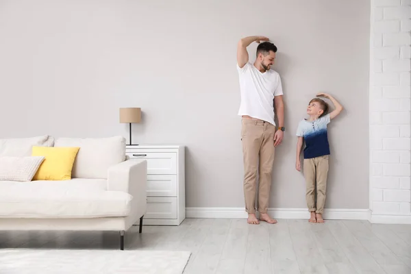 Padre Hijo Comparando Sus Alturas Cerca Pared Sala Estar —  Fotos de Stock