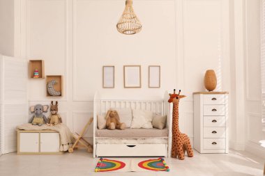 Bebek odasının içinde beşik ve oyuncaklar var.