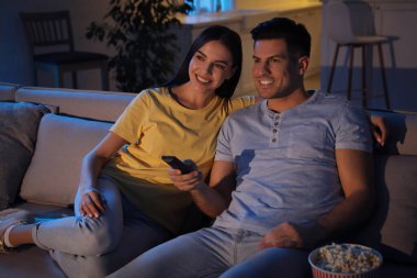 Geceleri koltukta patlamış mısırla film izleyen çift.