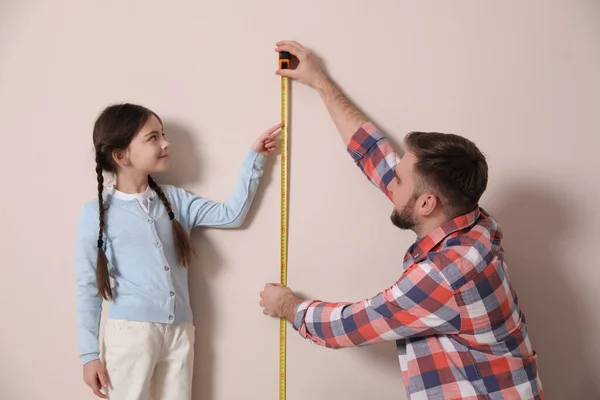 Baba Kızın Boyunu Bej Duvarın Yanında Ölçüyor — Stok fotoğraf